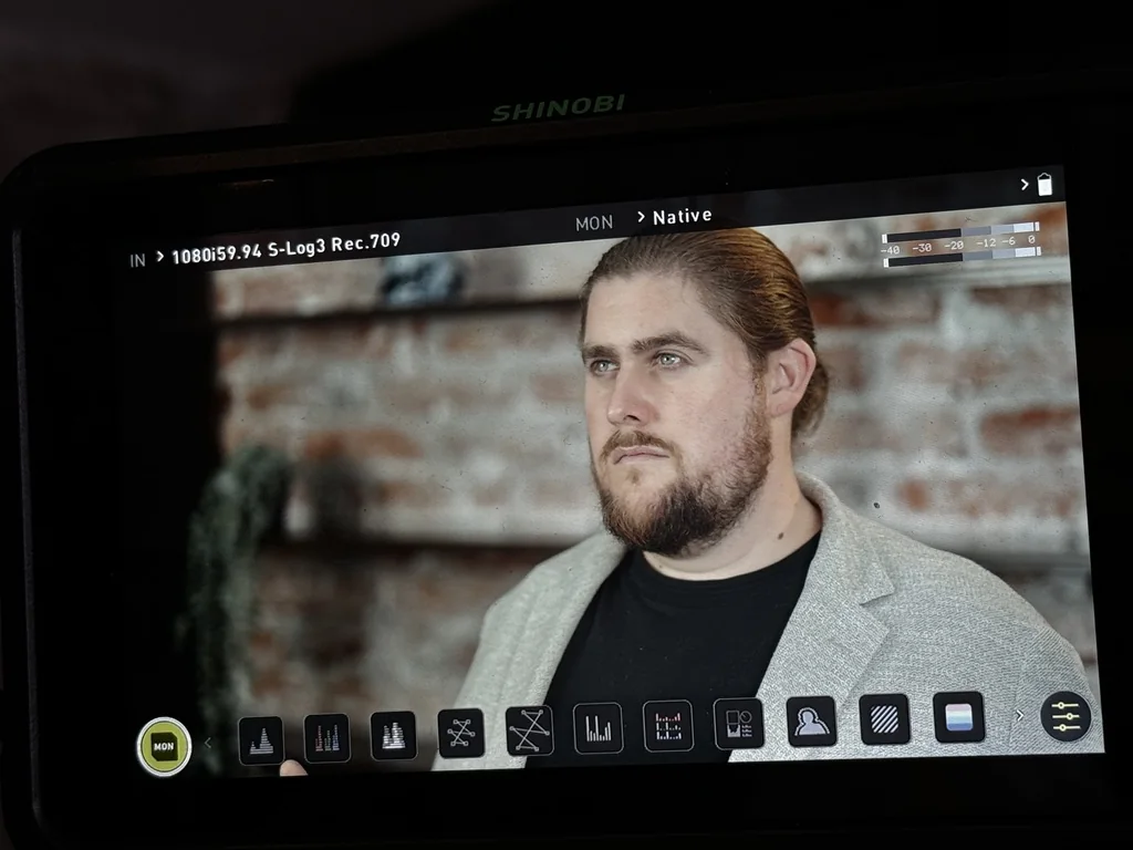 Behind-the-scenes camera monitor showing the framing of Michael’s interview