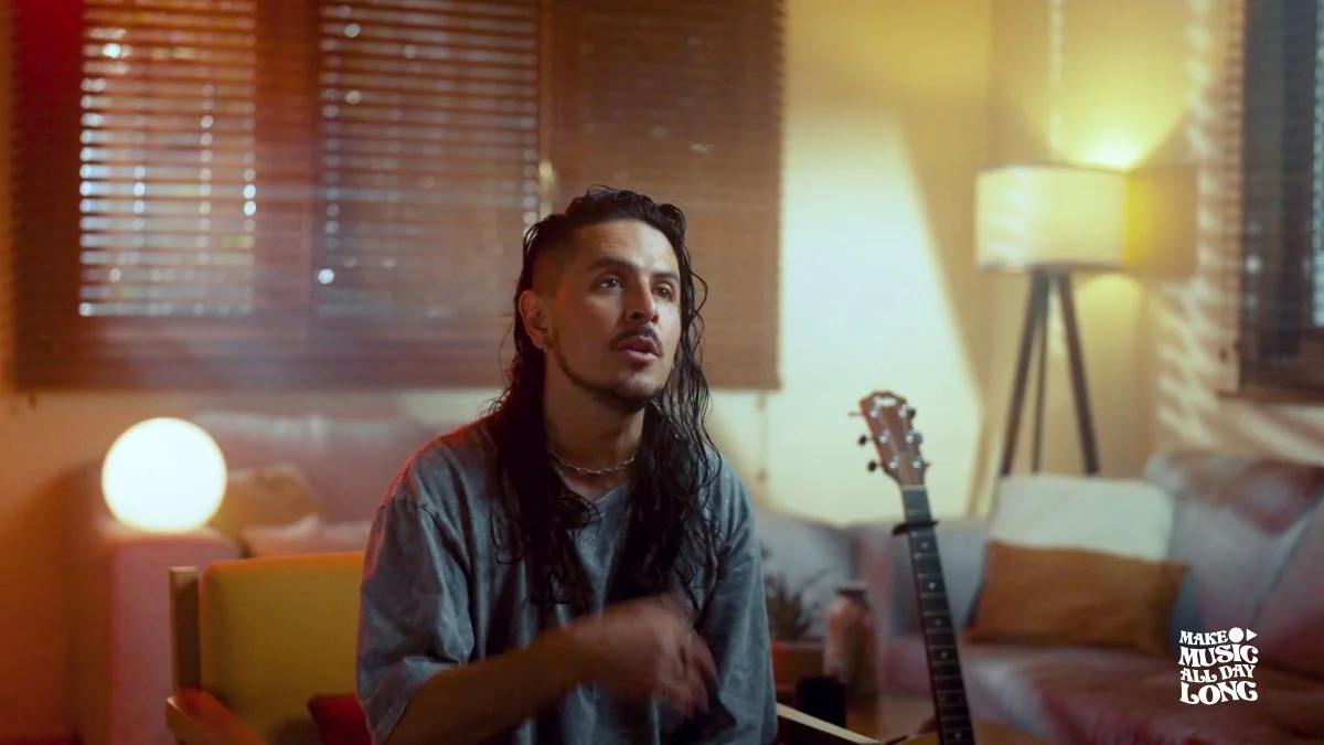 Erik Canales in a warmly lit room with his guitar